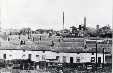 Photograph of four rows of terraced houses running across the photograph with the colliery buildings in the background; in the foreground are allotments; the chimneys of the colliery appear to have been scribbled on; the streets have been identified variously as The Eight Rows, The Four Rows and Inman, Silverdale and Morley Streets, South Hetton