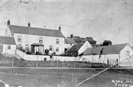 Photograph showing the front of a two storeyed house, with seven windows and a porch, outbuildings at the front can be seen on the right of the picture; the photograph has the words Gore Hall Thornley written on it