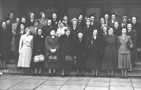 Photograph showing thirty three women dressed in overcoats standing in a group on the steps of a building; they have been identified as members of Thornley Women's Institute on an outing to an unidentified destination