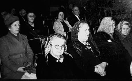Photograph showing seven elderly women wearing overcoats and headscarves, sitting on three rows of chairs; one elderly man can be seen sitting on the second row; the group has been identified as members of the Over Sixties Club in Thornley; the woman on the extreme left of the picture has been identified as Mrs. Ferguson; the woman on the left of the front row, wearing round spectacles, has been identified as Mrs. Griffiths