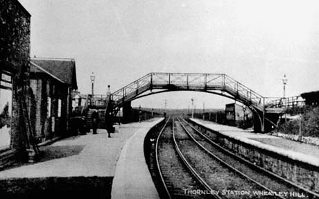 Postcard photograph entitled Thornley Station, Wheatley Hill, showing the rails running away from the camera and part of each platform; a footbridge can be seen in the distance crossing the line; two indistinct figures can be seen on the left-hand platform