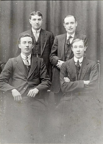 Photograph showing two young men sitting, and two young men standing behind them; all four are dressed in suits and ties; they have been identified as Jimmy Bell and Friends, Wingate