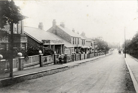Photograph showing a road running away from the camera; one side of the street can be seen; nearest to the camera is a detached house with two bay windows; next is a bungalow and, beyond that, terraced houses with substantial bay windows; a horse-drawn vehicle can be seen in the distance and an indistinct figure is standing on the pavement near the bungalow; the street has been identified as Front Street, Wingate