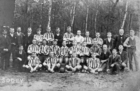 Photograph showing eighteen men in football strip accompanied by eleven other men in suits; they are posed against woodland; they have been identified as Albion Football Club, Wingate, runners-up in the Amateur Cup